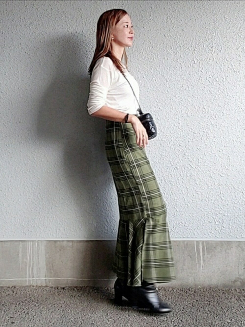 グリーン系のスカート、ブラック系のブーツ、ホワイト系のTシャツ/カットソーを着用したレディースの秋コーディネートの5枚目の写真