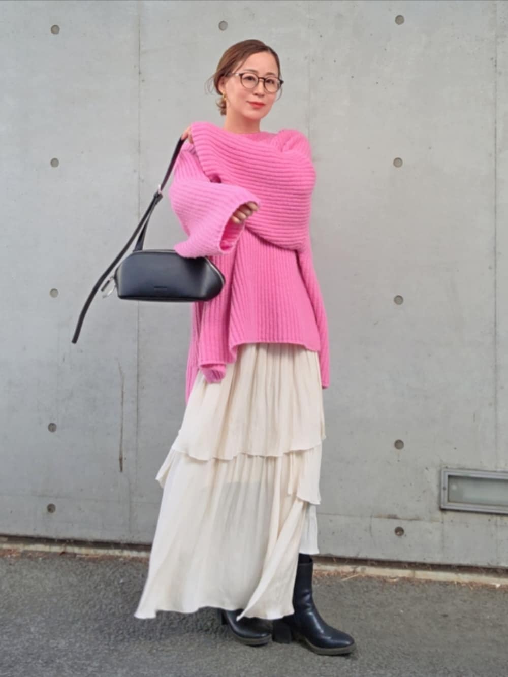 ピンク系のニット/セーター、ホワイト系のスカートを着用したレディースの春コーディネートの2枚目の写真