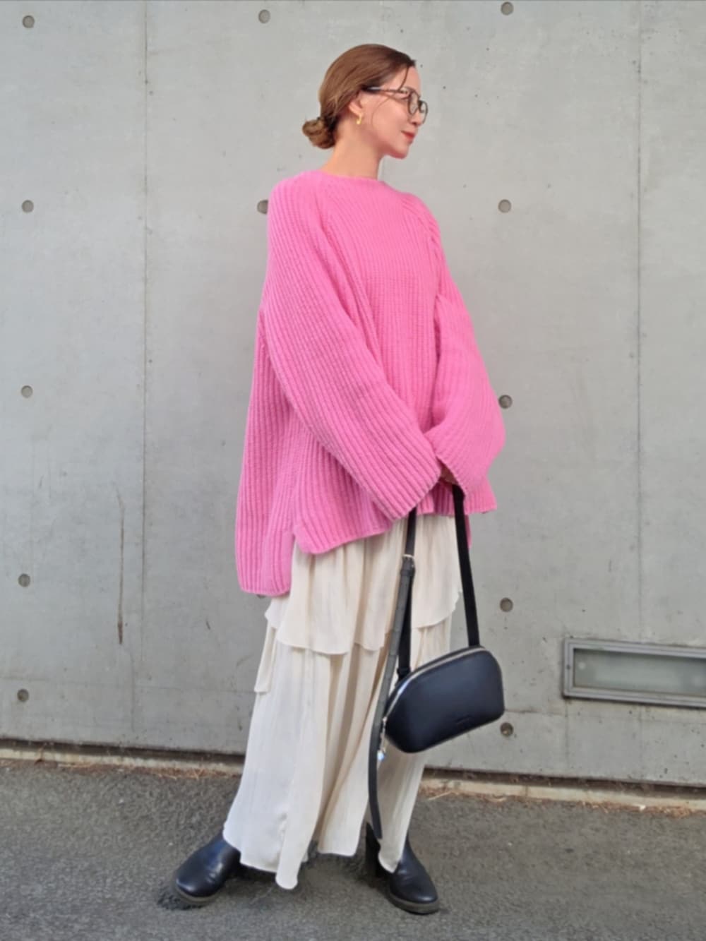 ピンク系のニット/セーター、ホワイト系のスカートを着用したレディースの春コーディネートの3枚目の写真