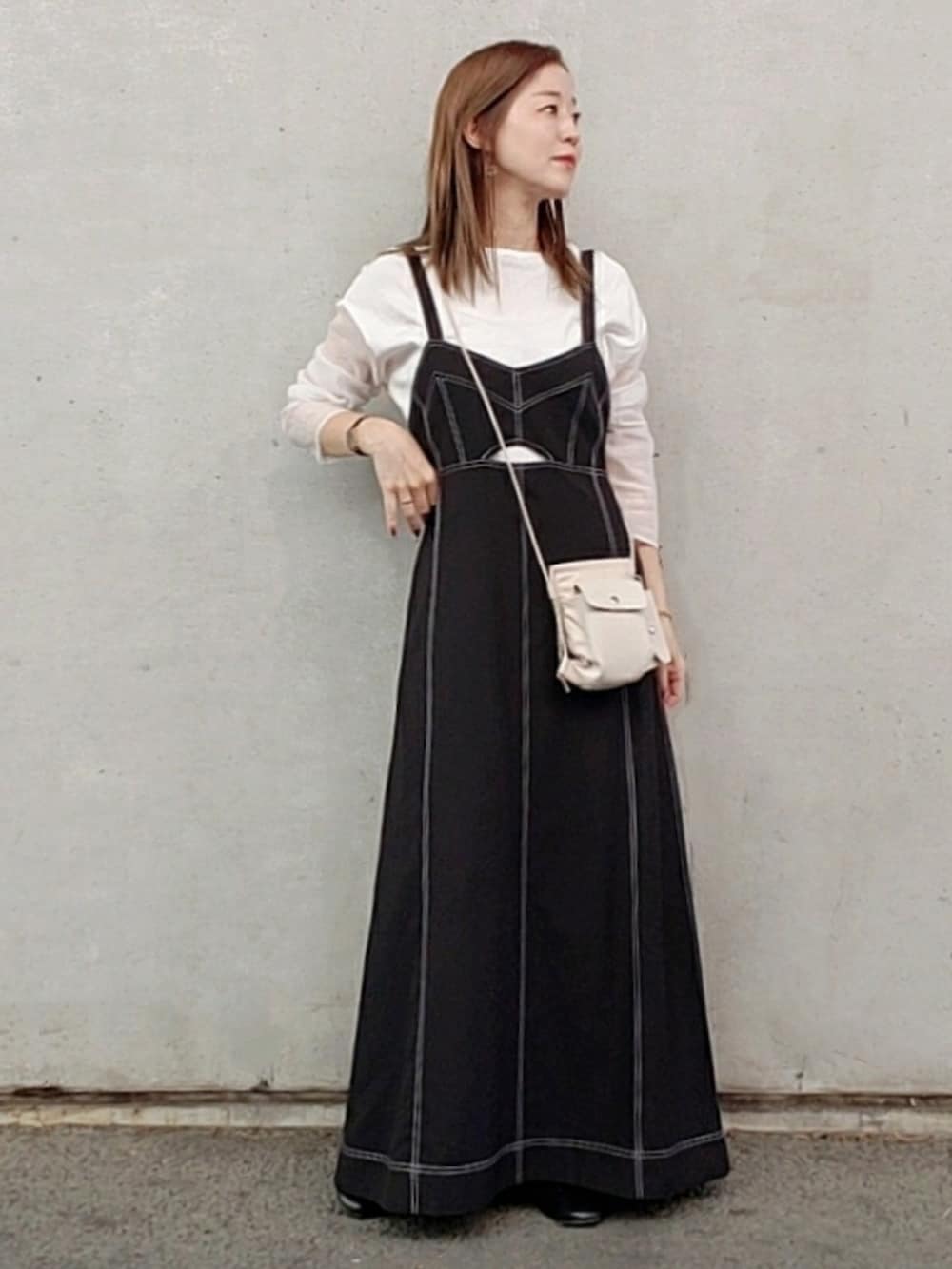 ブラック系のワンピース/ドレス、ホワイト系のショルダーバッグ、ホワイト系のTシャツ/カットソーを着用したレディースの春コーディネートの2枚目の写真