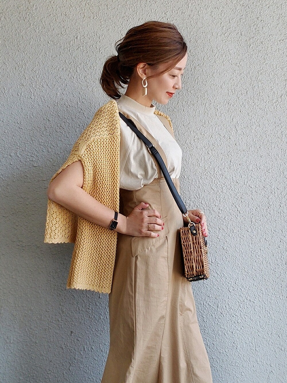 ベージュ系のスカート、ブラック系のサンダル、イエロー系のトップスを着用したレディースの春コーディネートの2枚目の写真