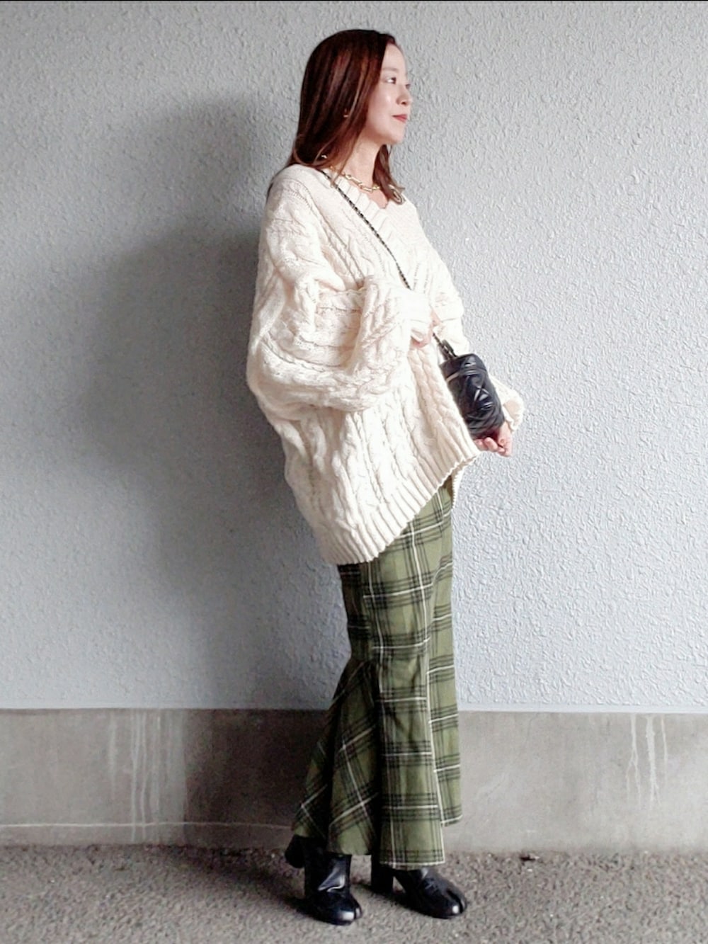 ホワイト系のニット/セーター、グリーン系のスカート、ブラック系のブーツを着用したレディースの秋コーディネートの3枚目の写真