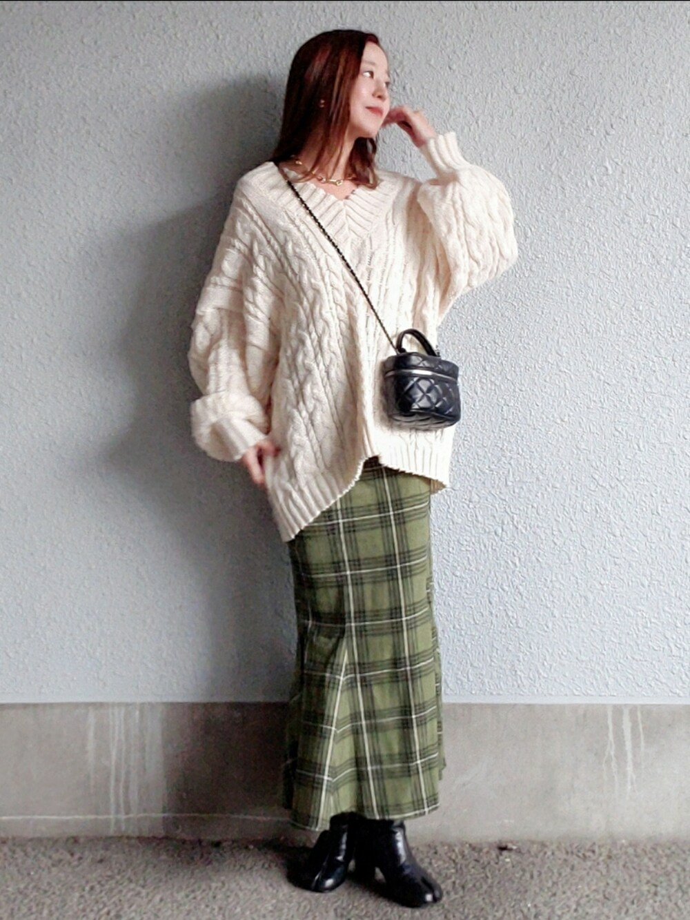 ホワイト系のニット/セーター、グリーン系のスカート、ブラック系のブーツを着用したレディースの秋コーディネートの4枚目の写真