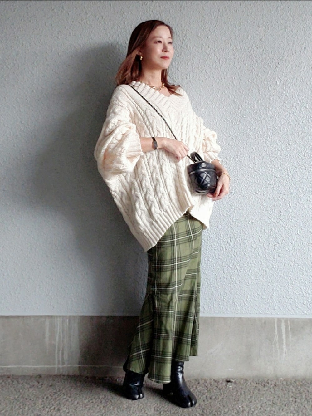 ホワイト系のニット/セーター、グリーン系のスカート、ブラック系のブーツを着用したレディースの秋コーディネートの2枚目の写真