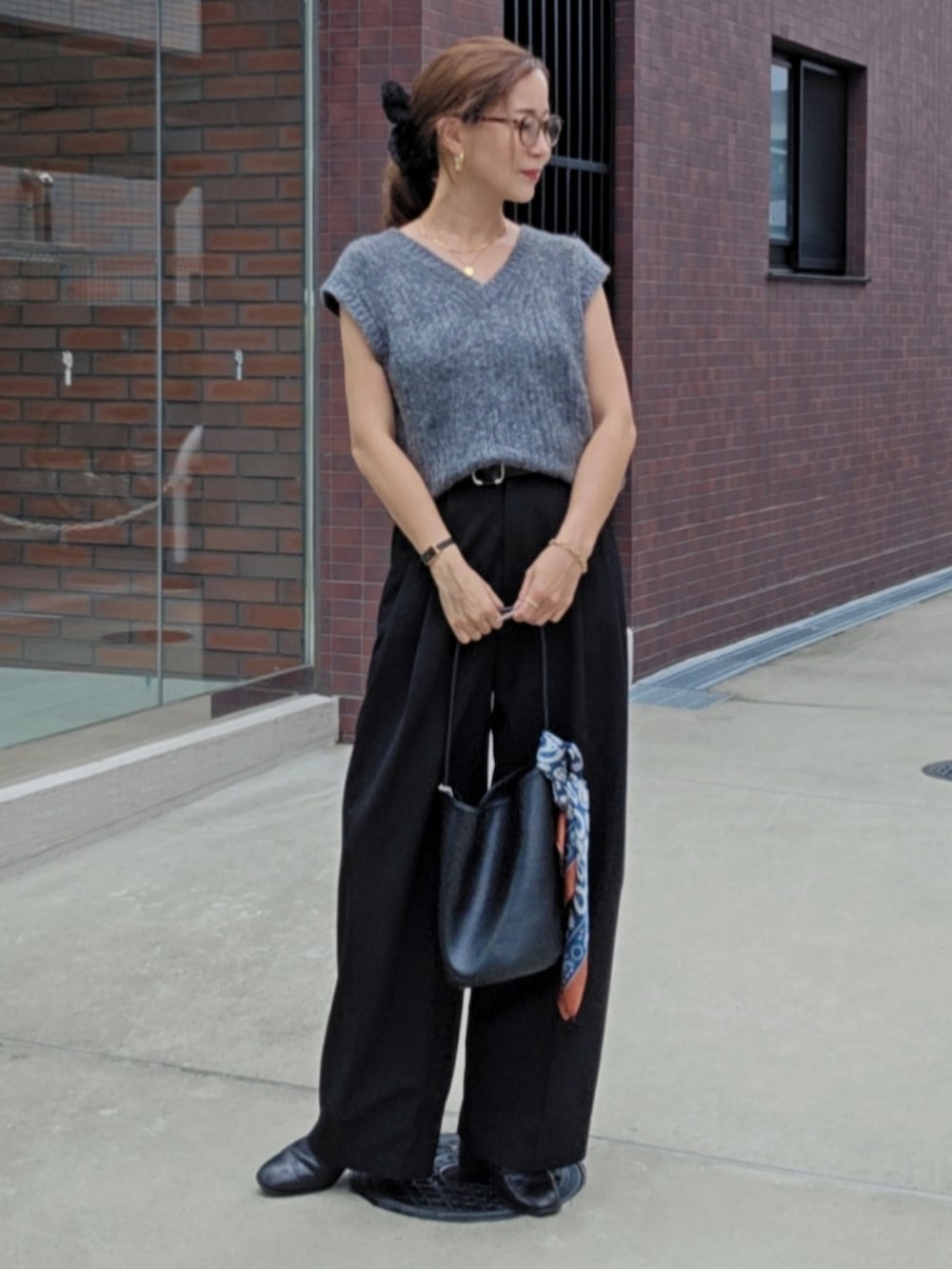 グレー系のベスト、ブラック系のスラックスを着用したレディースの秋コーディネートの3枚目の写真
