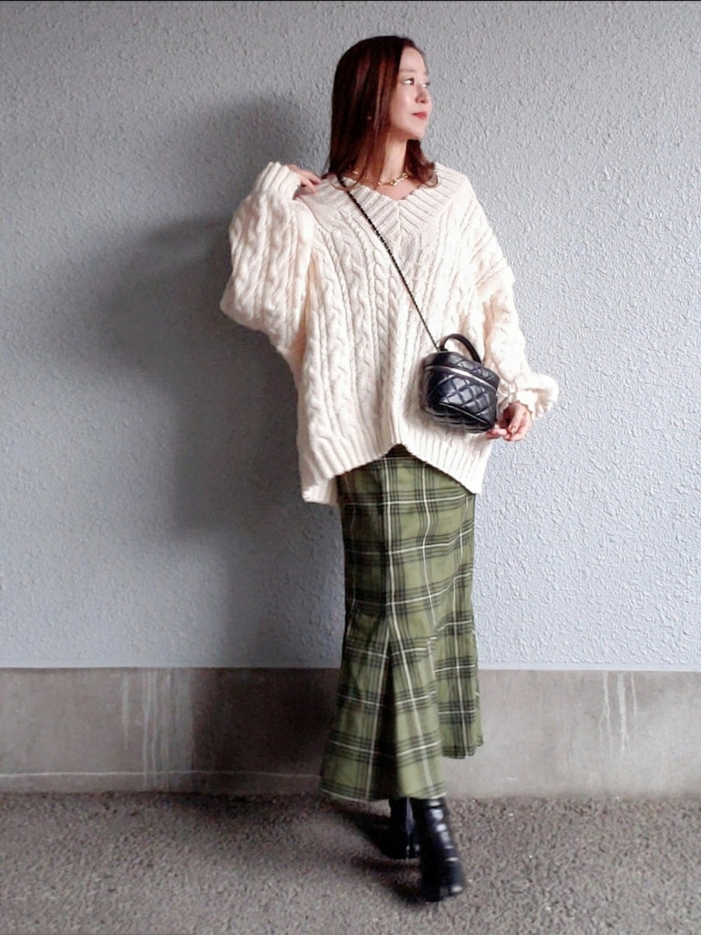 ホワイト系のニット/セーター、グリーン系のスカート、ブラック系のブーツを着用したレディースの秋コーディネートの5枚目の写真