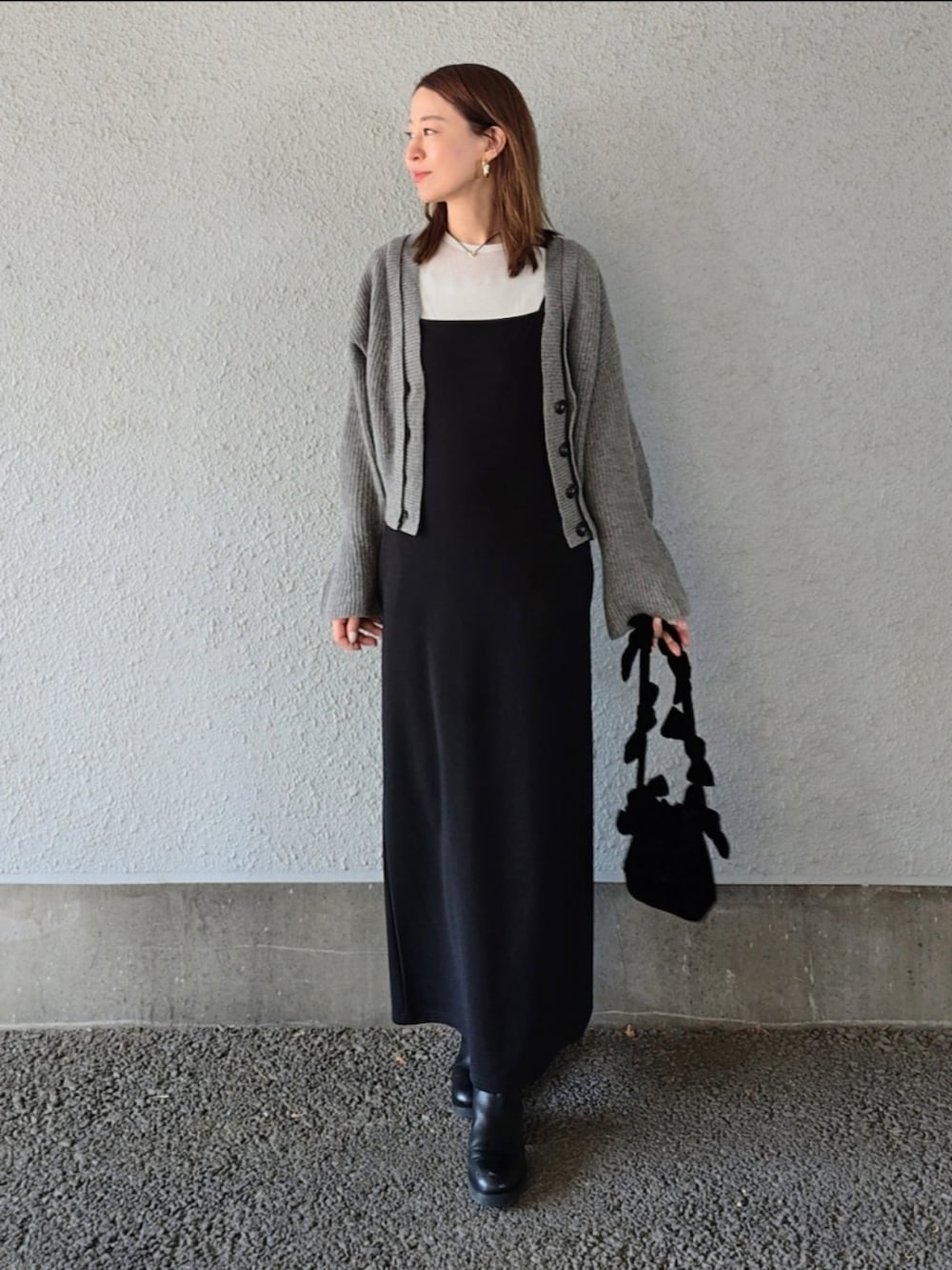 ブラック系のワンピース、ブラック系のバッグ、ブラック系のパンプスを着用したレディースの秋コーディネートの2枚目の写真