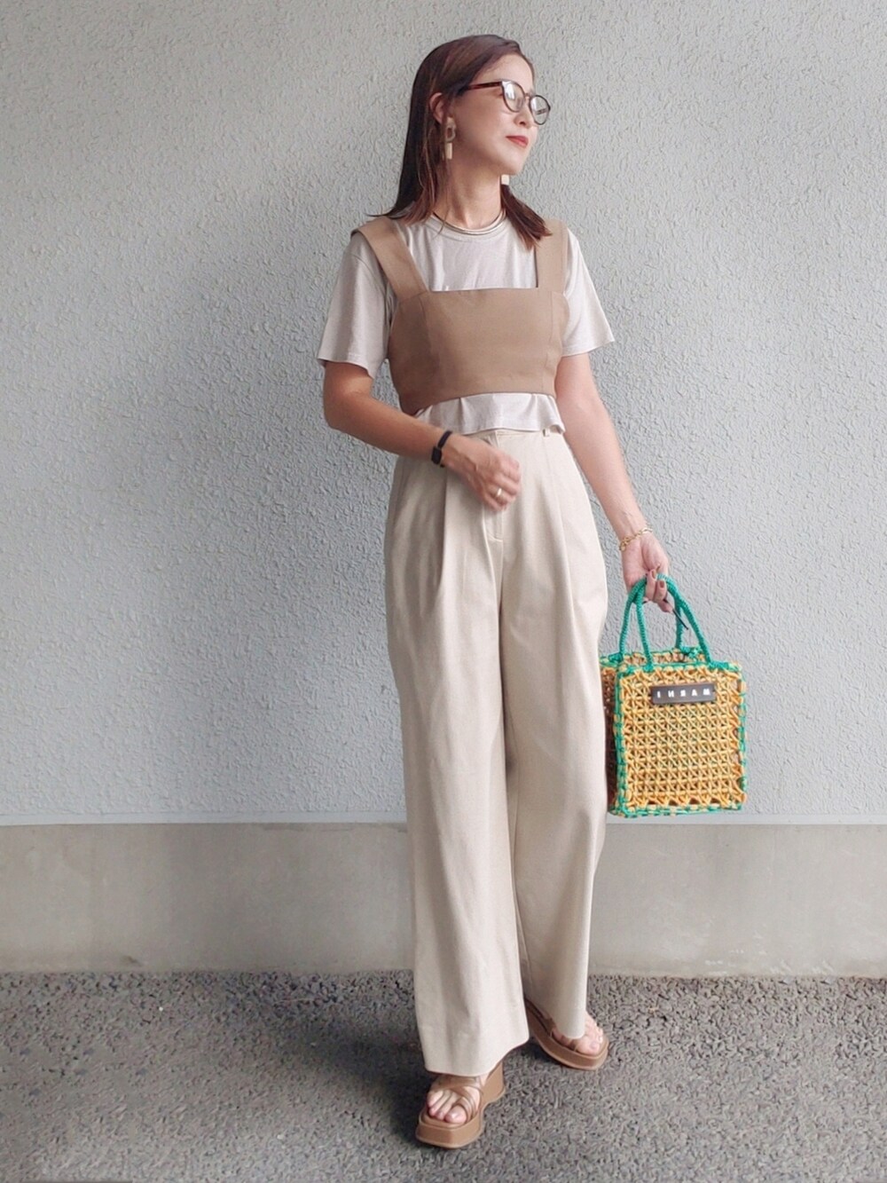 イエロー系のバッグ、ブラウン系のサンダル、グレー系のTシャツ/カットソーを着用したレディースの夏コーディネートの2枚目の写真