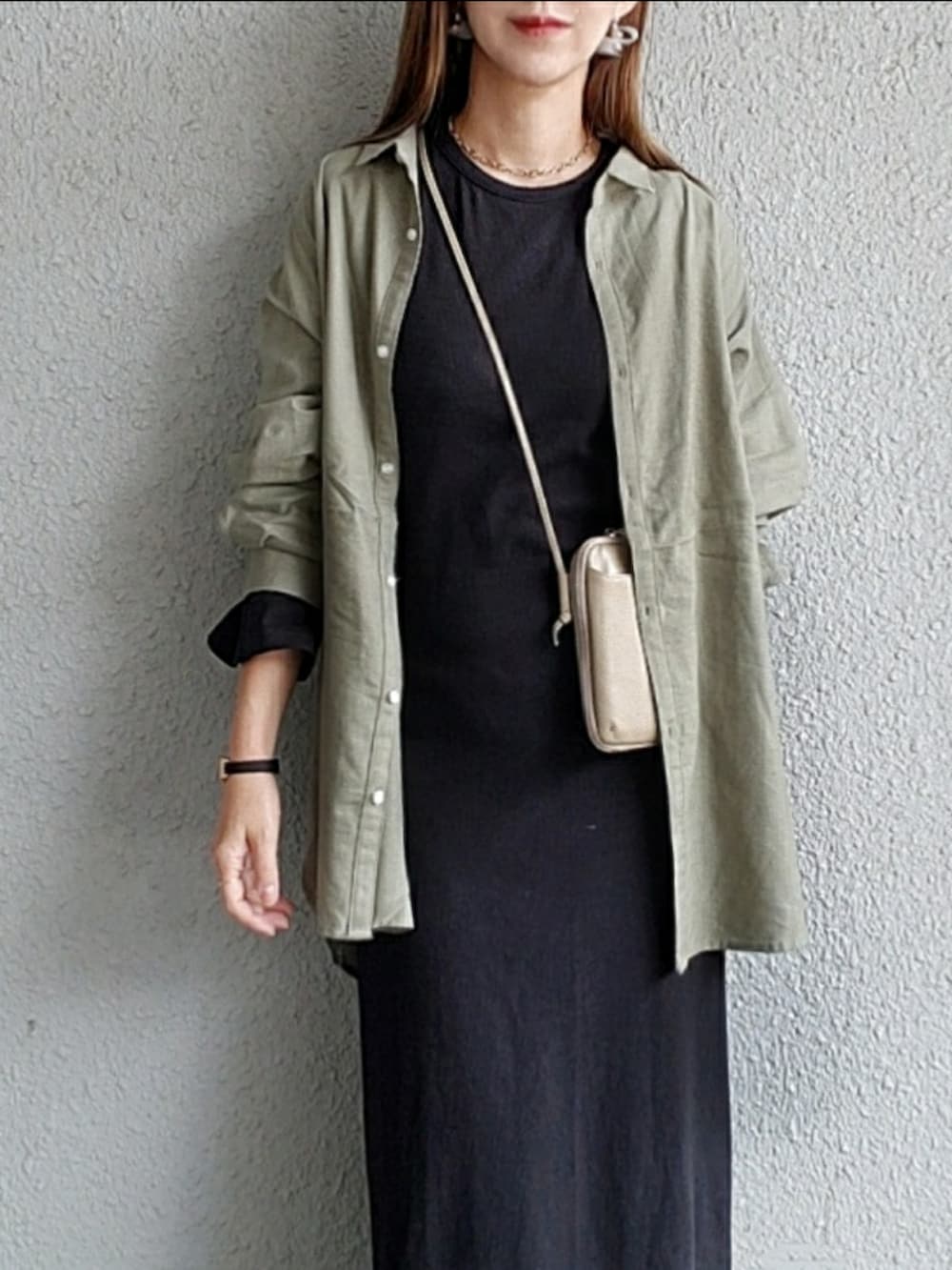 グリーン系のシャツ/ブラウス、ブラック系のワンピース、ベージュ系のスニーカーを着用したレディースの春コーディネートの4枚目の写真