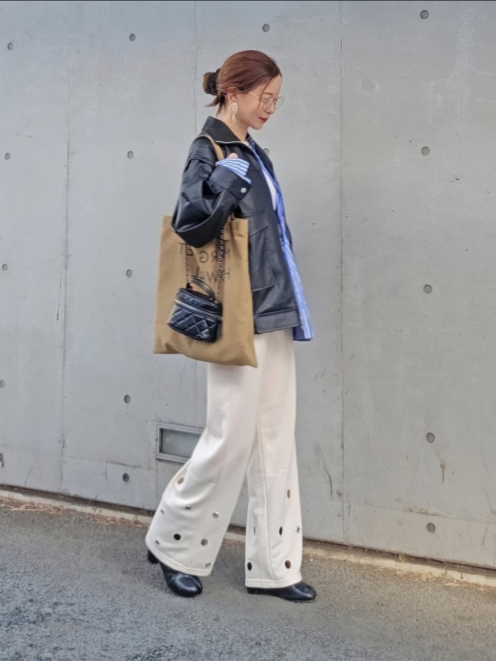ブラック系のライダースジャケット、ホワイト系のスウェットパンツ、ブルー系のシャツ/ブラウスを着用したレディースの春コーディネートの2枚目の写真