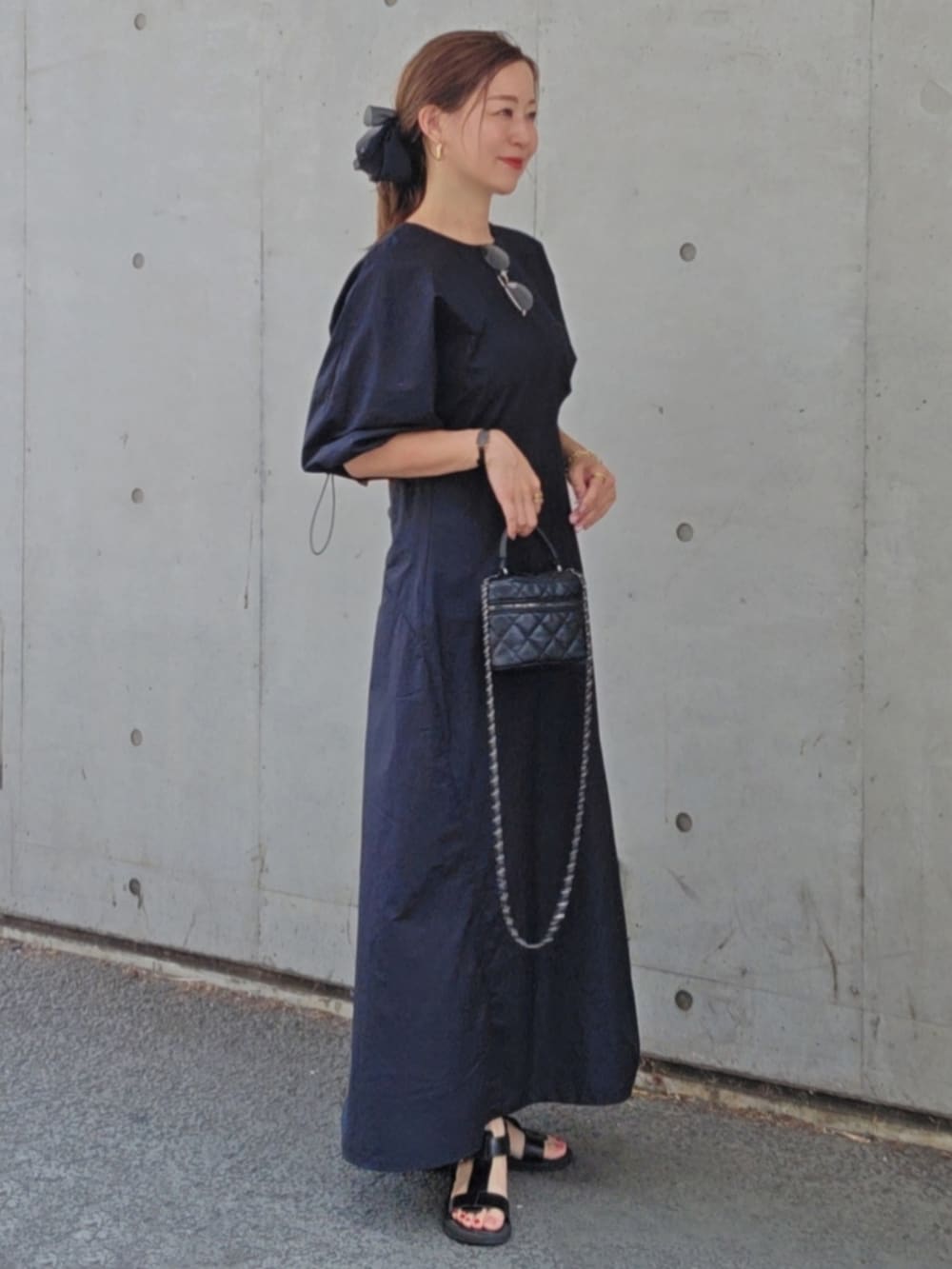 ブラック系のワンピース/ドレス、ブラック系のバッグ、ブラック系のサンダルを着用したレディースの夏コーディネートの4枚目の写真