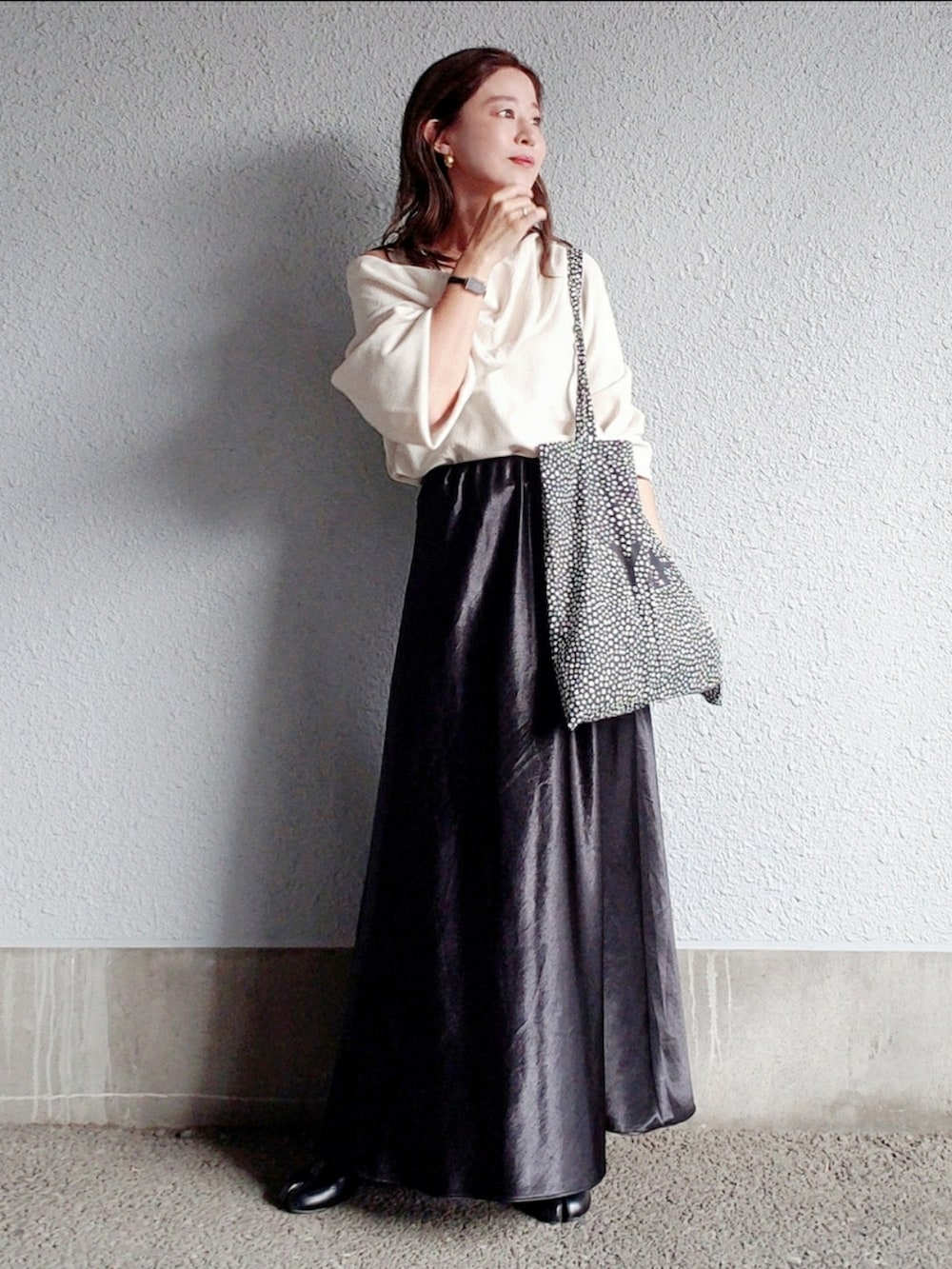 ホワイト系のTシャツ/カットソー、ブラック系のスカート、ブラック系のブーツを着用したレディースの秋コーディネートの2枚目の写真