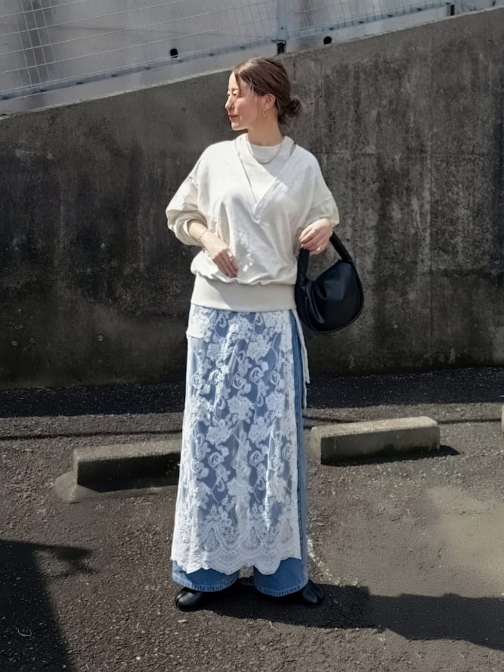 ベージュ系のTシャツ/カットソー、ホワイト系のスカート、ブルー系のデニムパンツを着用したレディースの春コーディネートの2枚目の写真