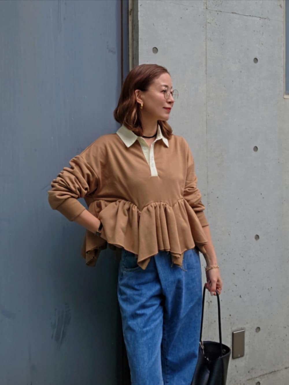 イエロー系のスウェット、ブルー系のデニムパンツ、ブラック系のパンプスを着用したレディースの春コーディネートの5枚目の写真