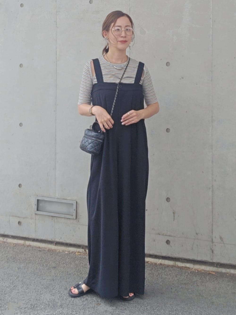 グレー系のTシャツ/カットソー、ブラック系のサンダルを着用したレディースの夏コーディネートの2枚目の写真