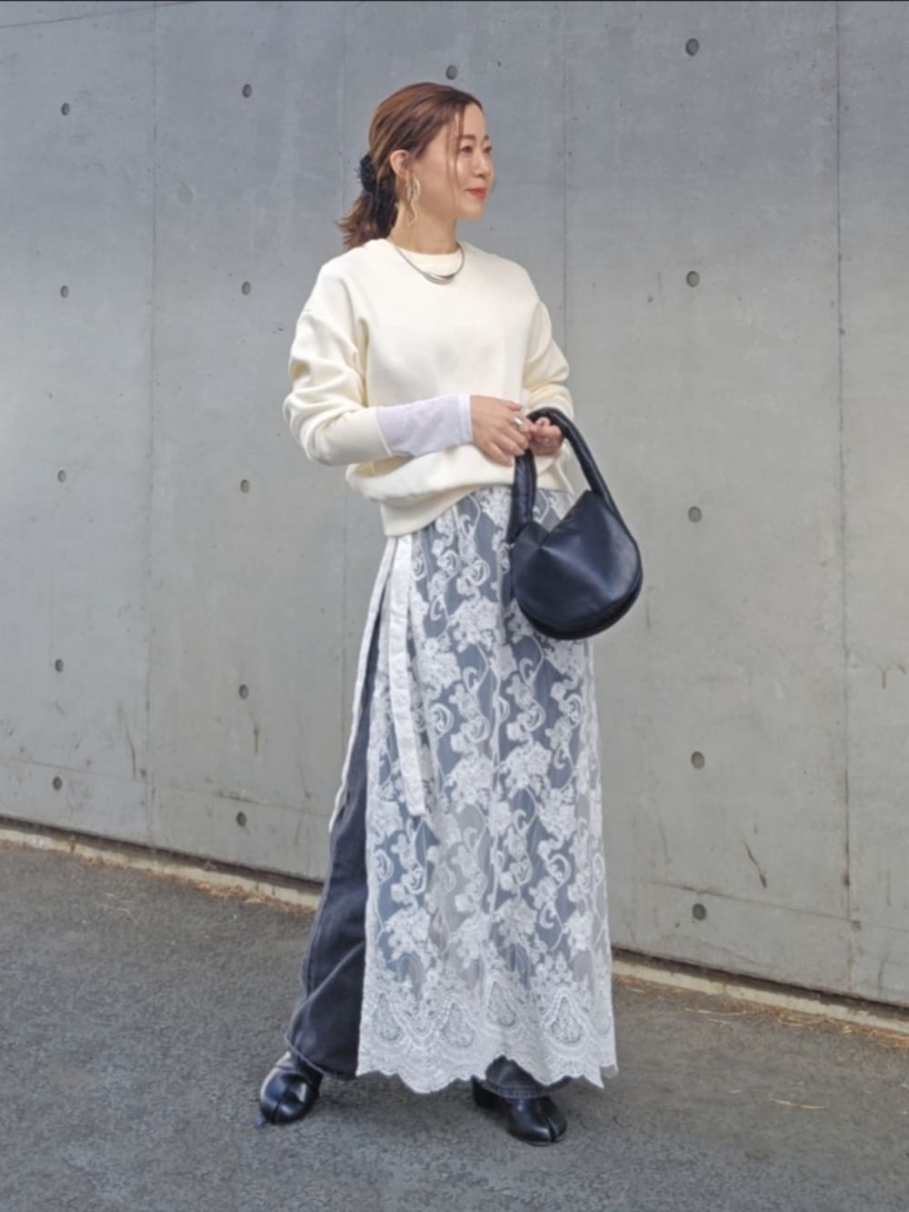 ホワイト系のニット/セーター、ホワイト系のスカート、ブラック系のデニムパンツを着用したレディースの冬コーディネートの4枚目の写真