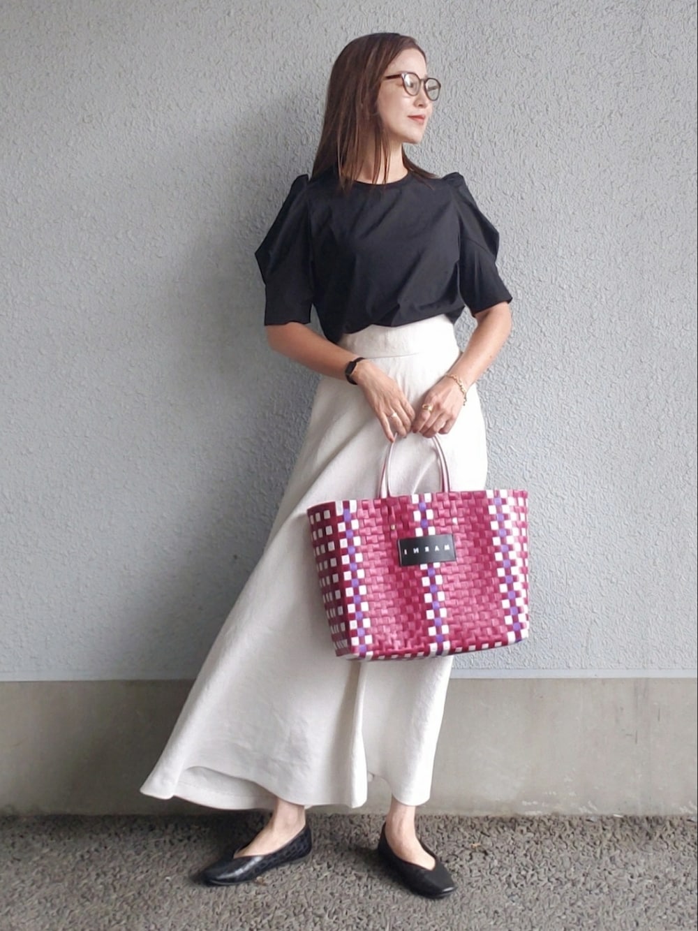 ホワイト系のスカート、ブラック系のTシャツ/カットソー、ブラック系のパンプスを着用したレディースの夏コーディネートの2枚目の写真