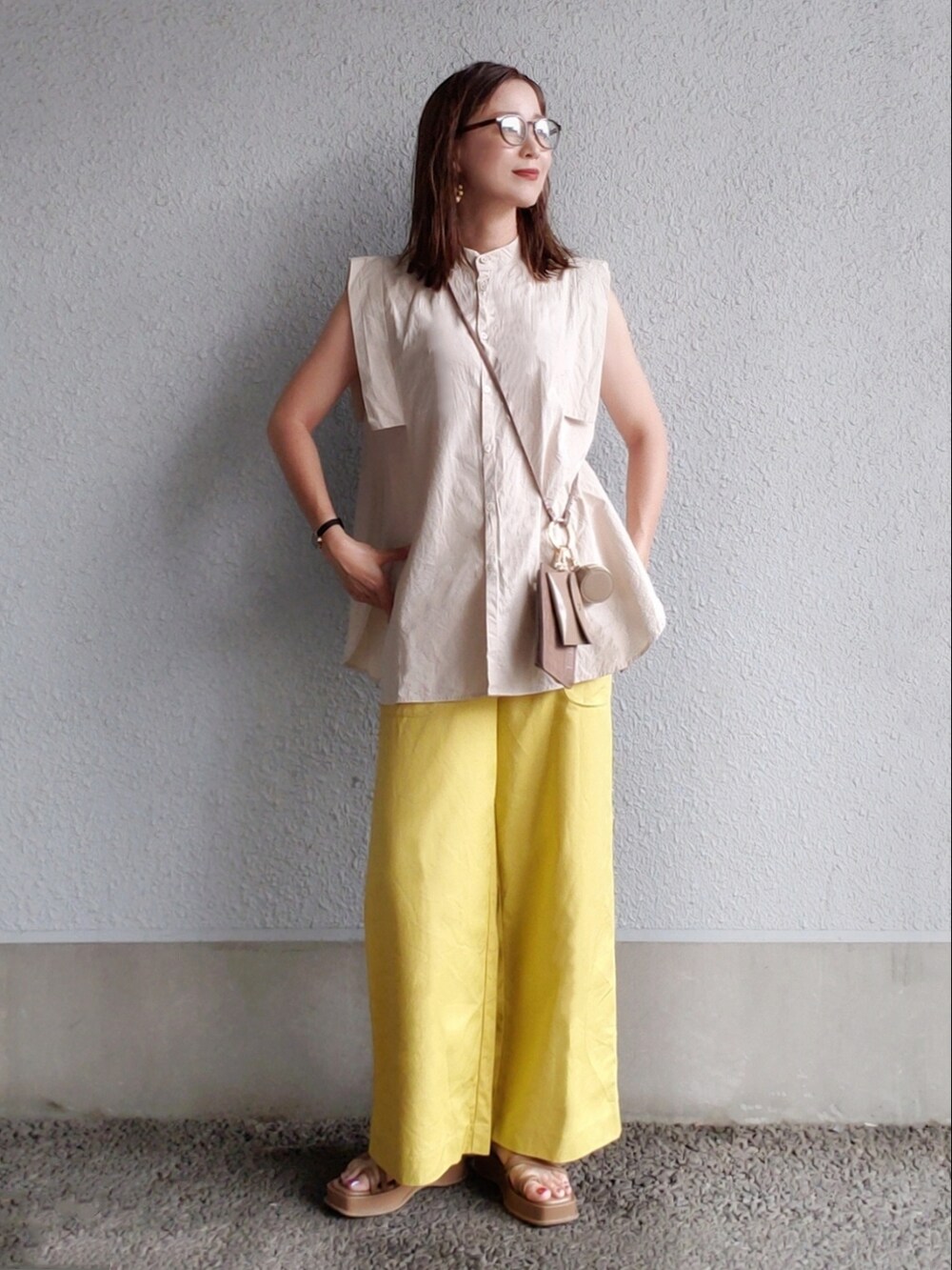 ブラウン系のサンダル、イエロー系のその他パンツ、ブラウン系のショルダーバッグを着用したレディースの夏コーディネートの2枚目の写真