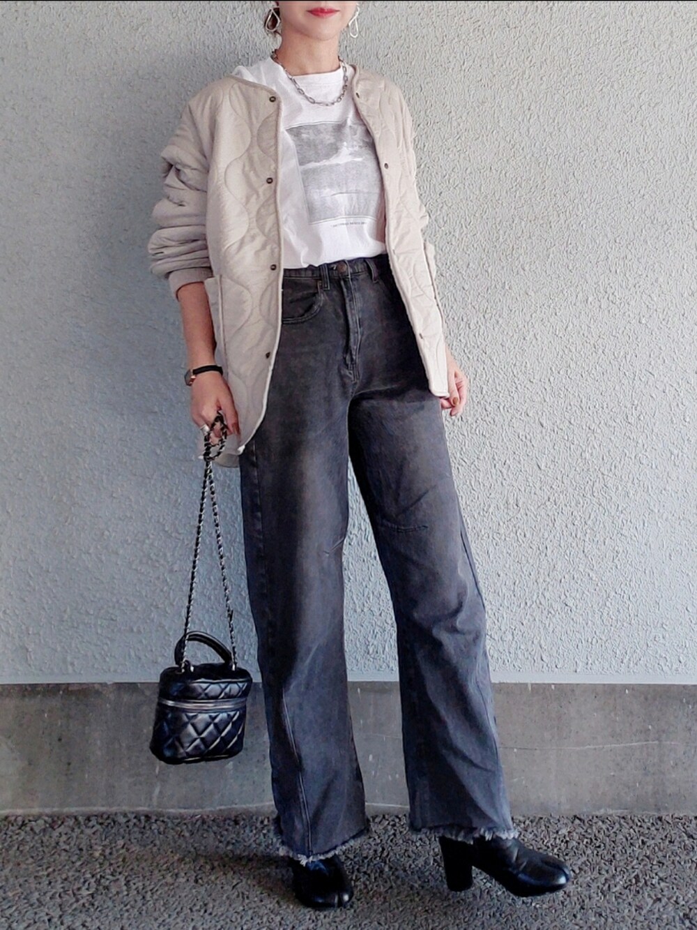 ベージュ系のブルゾン、ブラック系のパンツ、ブラック系のブーツを着用したレディースの秋コーディネートの2枚目の写真