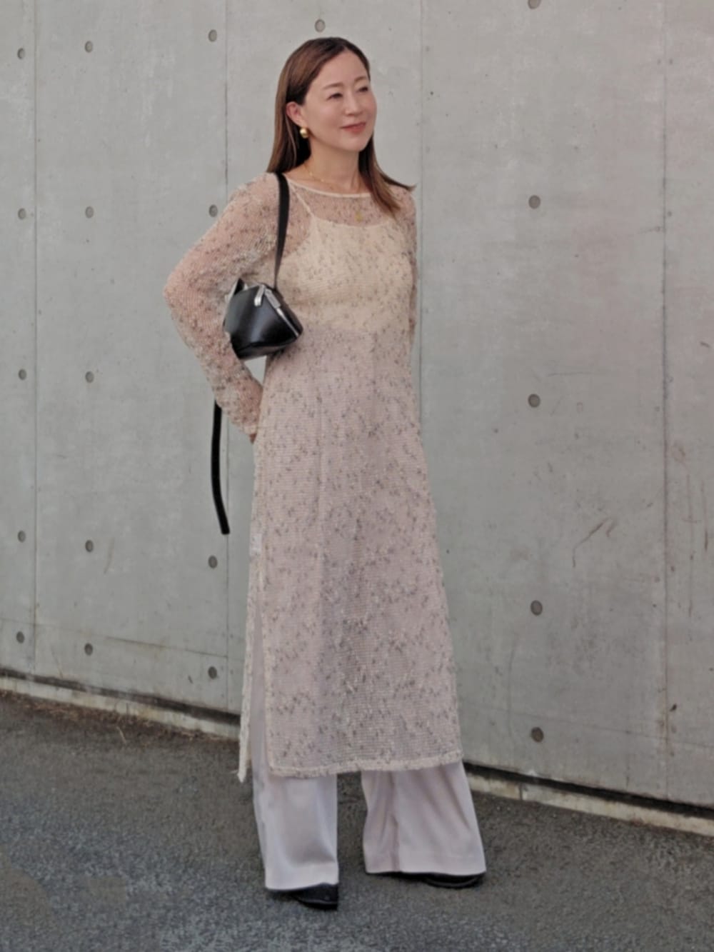 ホワイト系のワンピース、ホワイト系のその他パンツ、ブラック系のショルダーバッグを着用したレディースの夏コーディネートの2枚目の写真