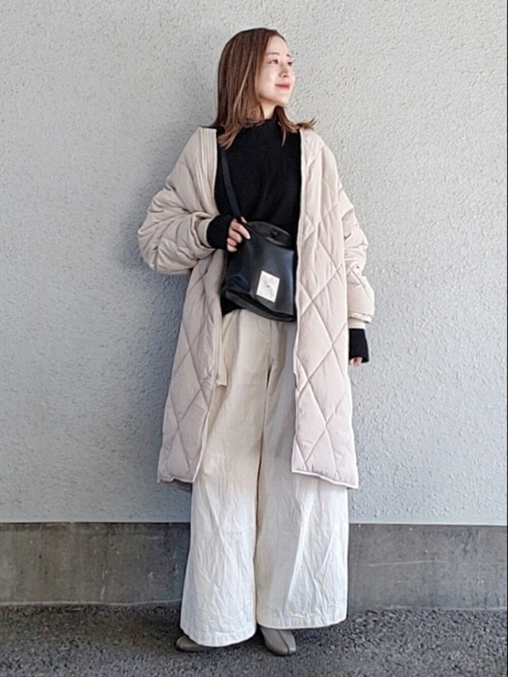 ホワイト系のダウンジャケット/コート、ブラック系のショルダーバッグ、ホワイト系のその他パンツを着用したレディースの冬コーディネートの3枚目の写真