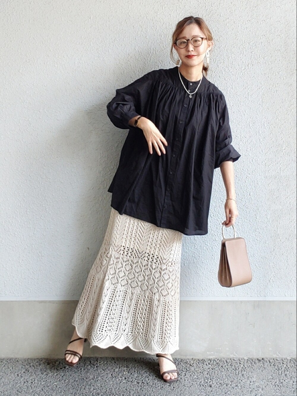 ブラック系のシャツ/ブラウス、ホワイト系のスカート、ブラウン系のサンダルを着用したレディースの夏コーディネートの2枚目の写真