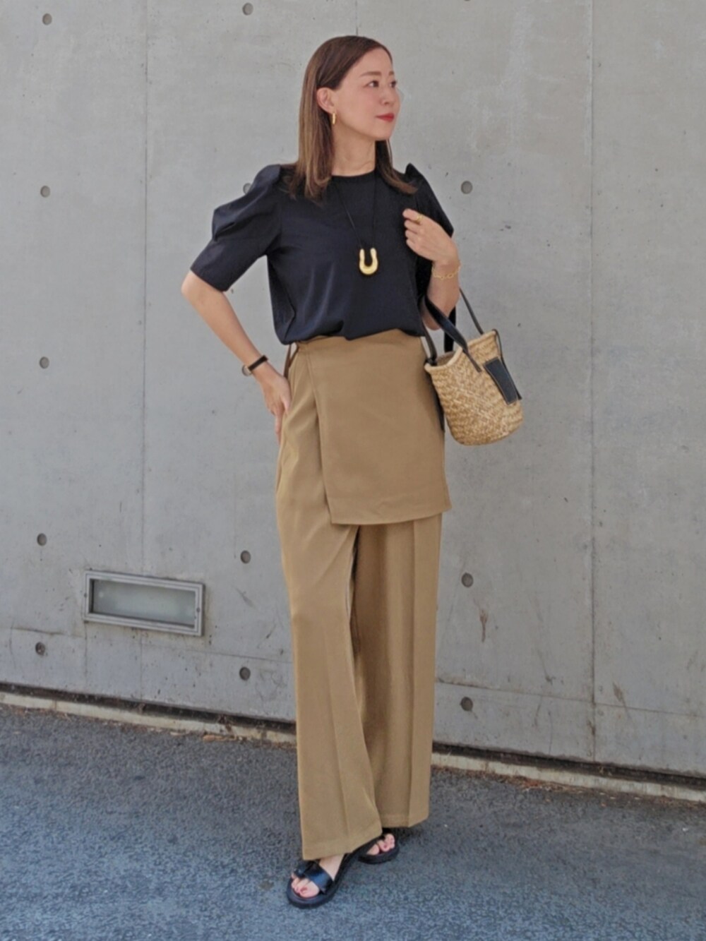 ブラック系のTシャツ/カットソー、ベージュ系のスラックス、ブラック系のサンダルを着用したレディースの夏コーディネートの3枚目の写真