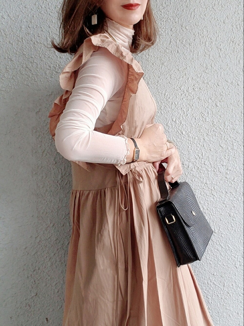 ブラウン系のワンピース、ベージュ系のTシャツ/カットソー、ブラック系のショルダーバッグを着用したレディースの春コーディネートの2枚目の写真