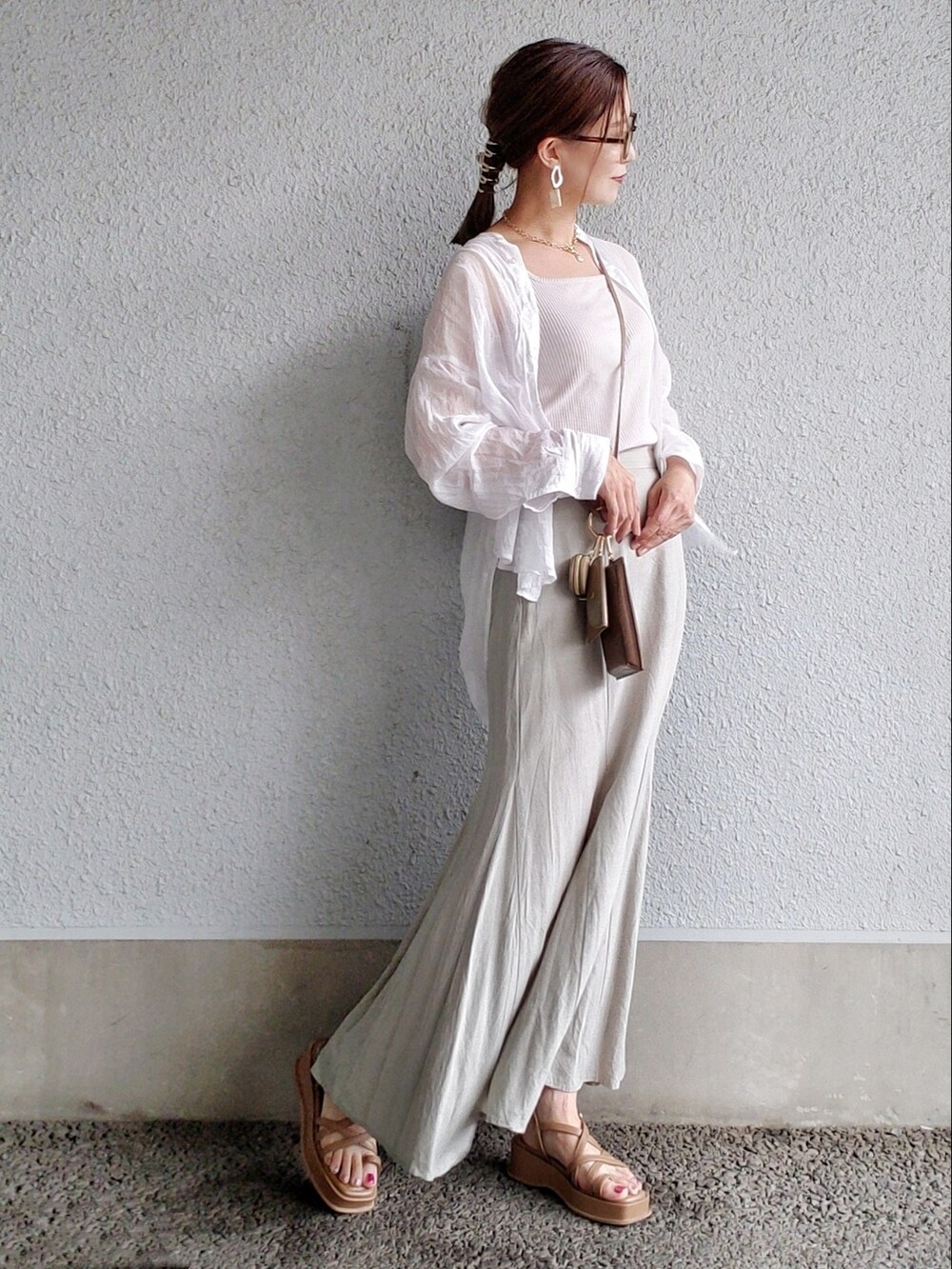 グリーン系のスカート、ブラウン系のサンダル、ブラウン系のショルダーバッグを着用したレディースの夏コーディネートの2枚目の写真