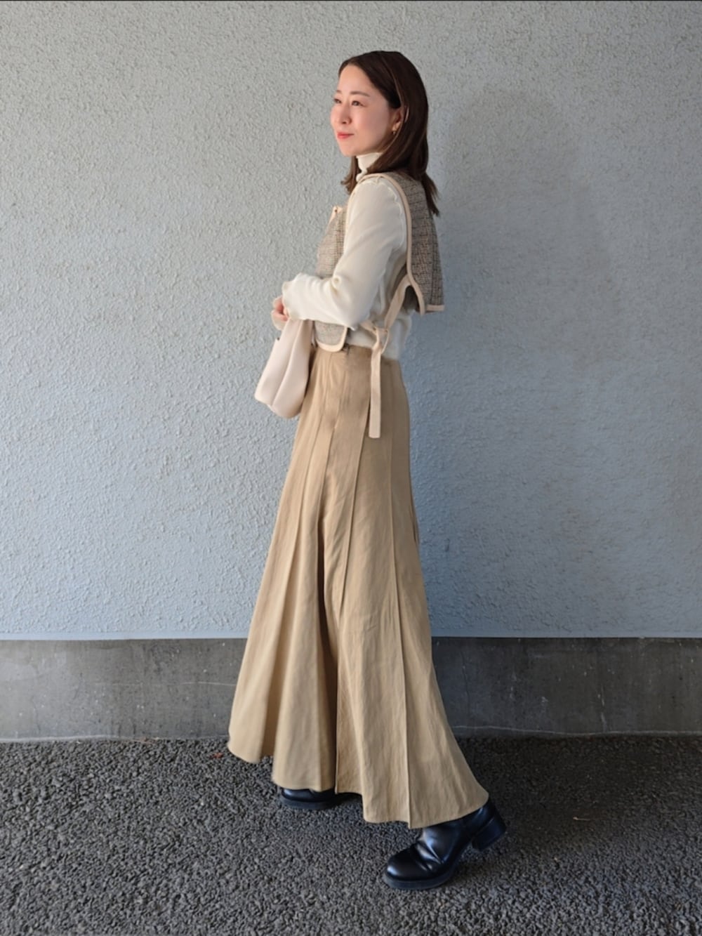 ベージュ系のベスト、ベージュ系のスカート、ブラック系のパンプスを着用したレディースの冬コーディネートの3枚目の写真