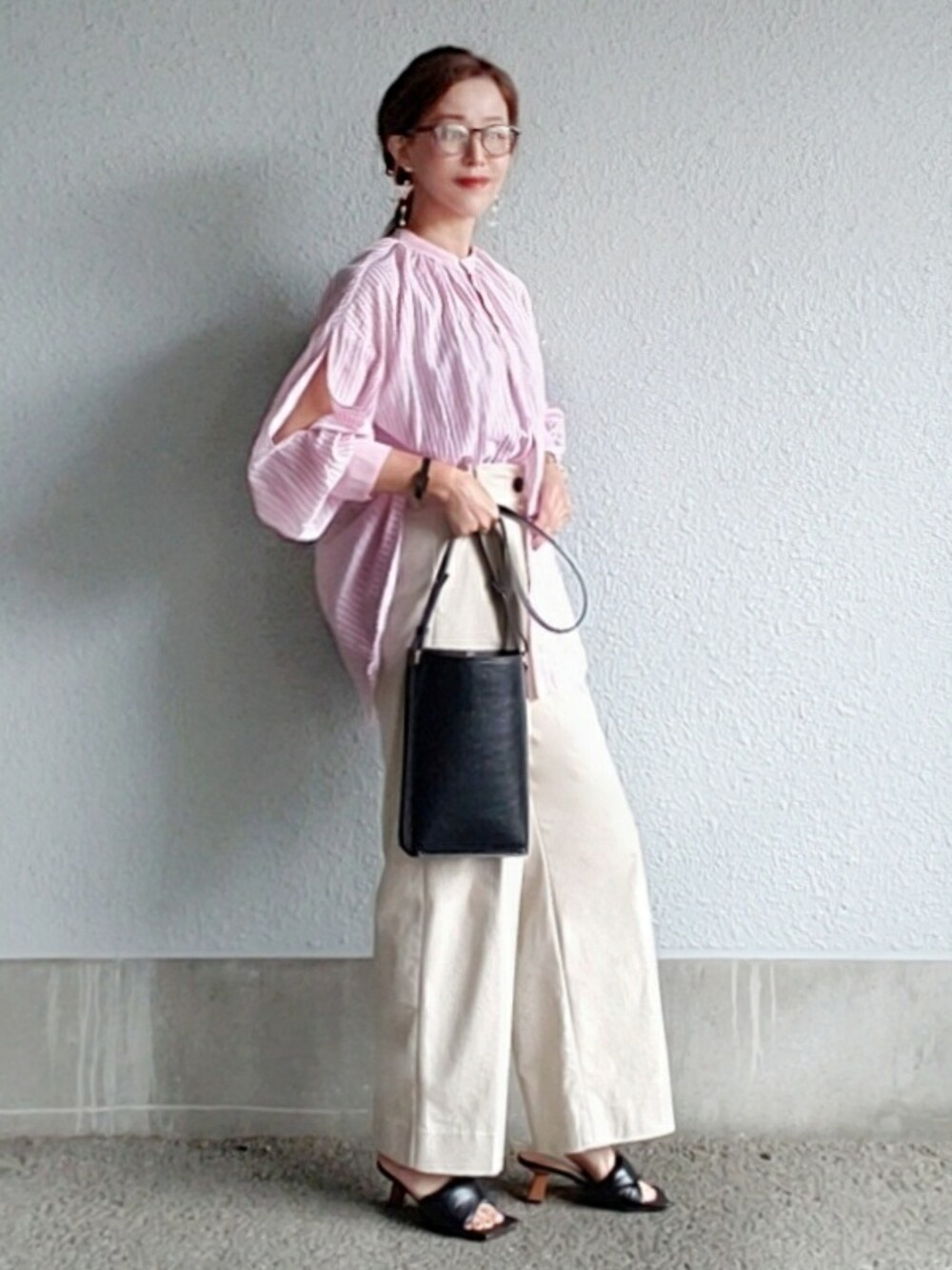 ブラック系のサンダル、ピンク系のシャツ/ブラウス、ブラック系のバッグを着用したレディースの春コーディネートの3枚目の写真