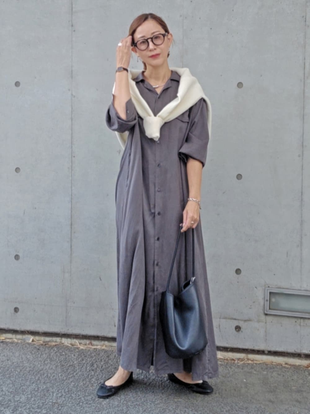 グレー系のワンピース、ホワイト系のニット/セーター、ブラック系のパンプスを着用したレディースの秋コーディネートの2枚目の写真