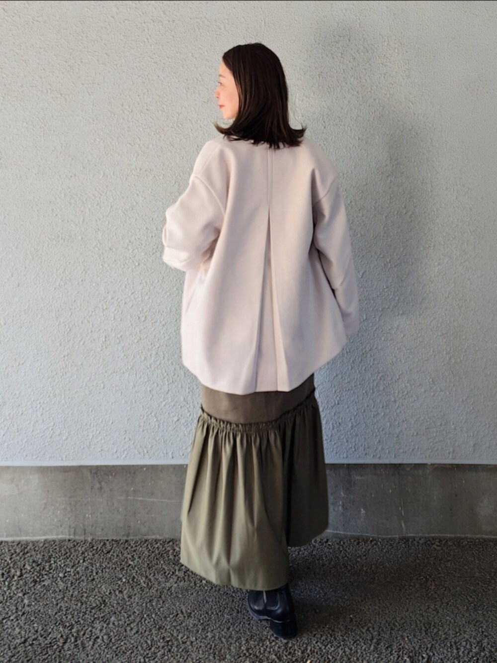 グリーン系のワンピースを着用したレディースの冬コーディネートの5枚目の写真