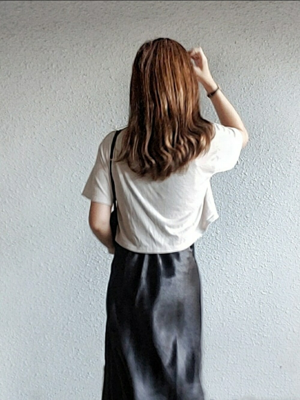 グレー系のTシャツ/カットソー、ブラック系のスカート、グレー系のサンダルを着用したレディースの秋コーディネートの2枚目の写真