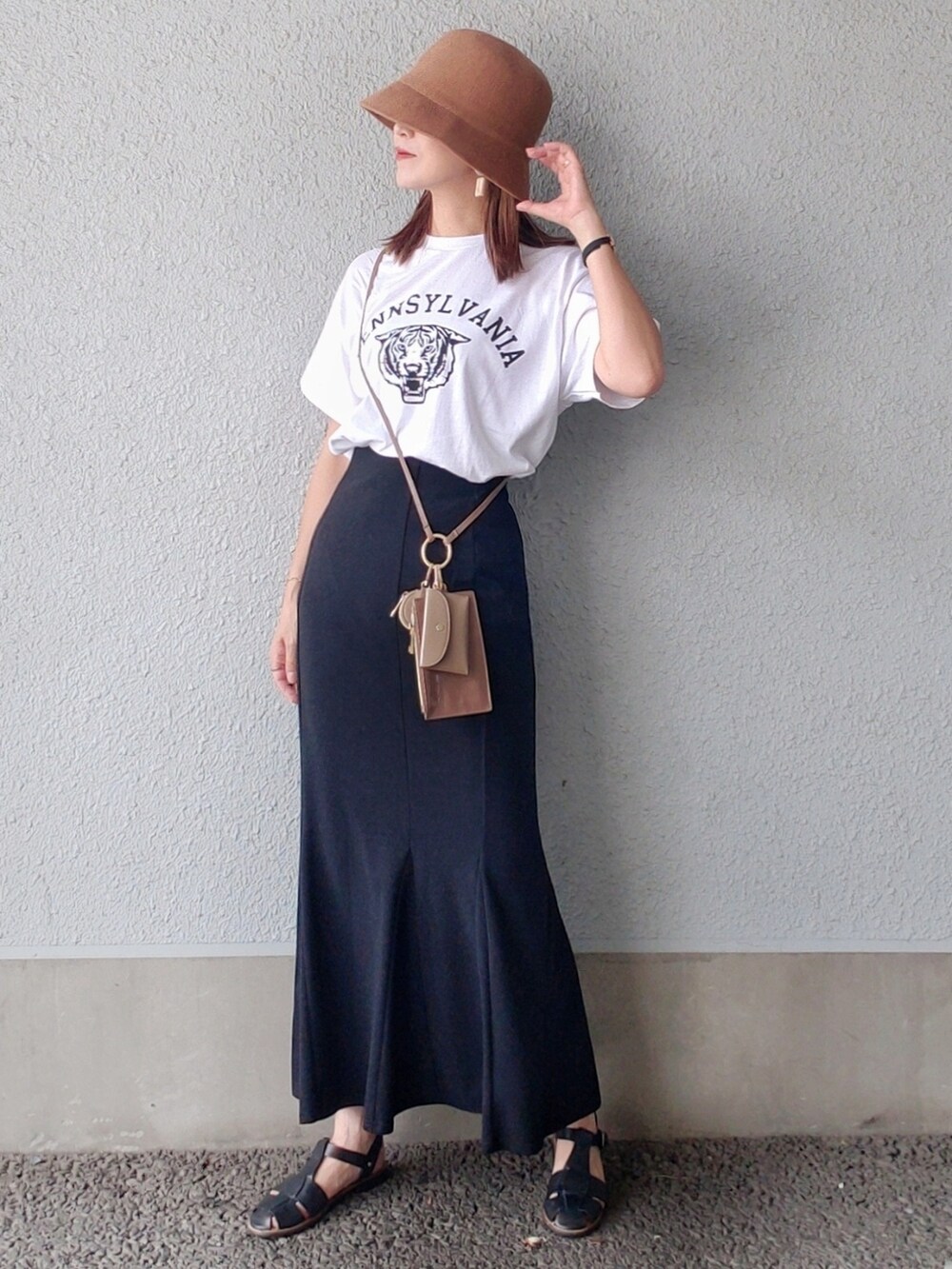 ホワイト系のTシャツ/カットソー、ブラック系のスカート、ブラック系のサンダルを着用したレディースの夏コーディネートの2枚目の写真
