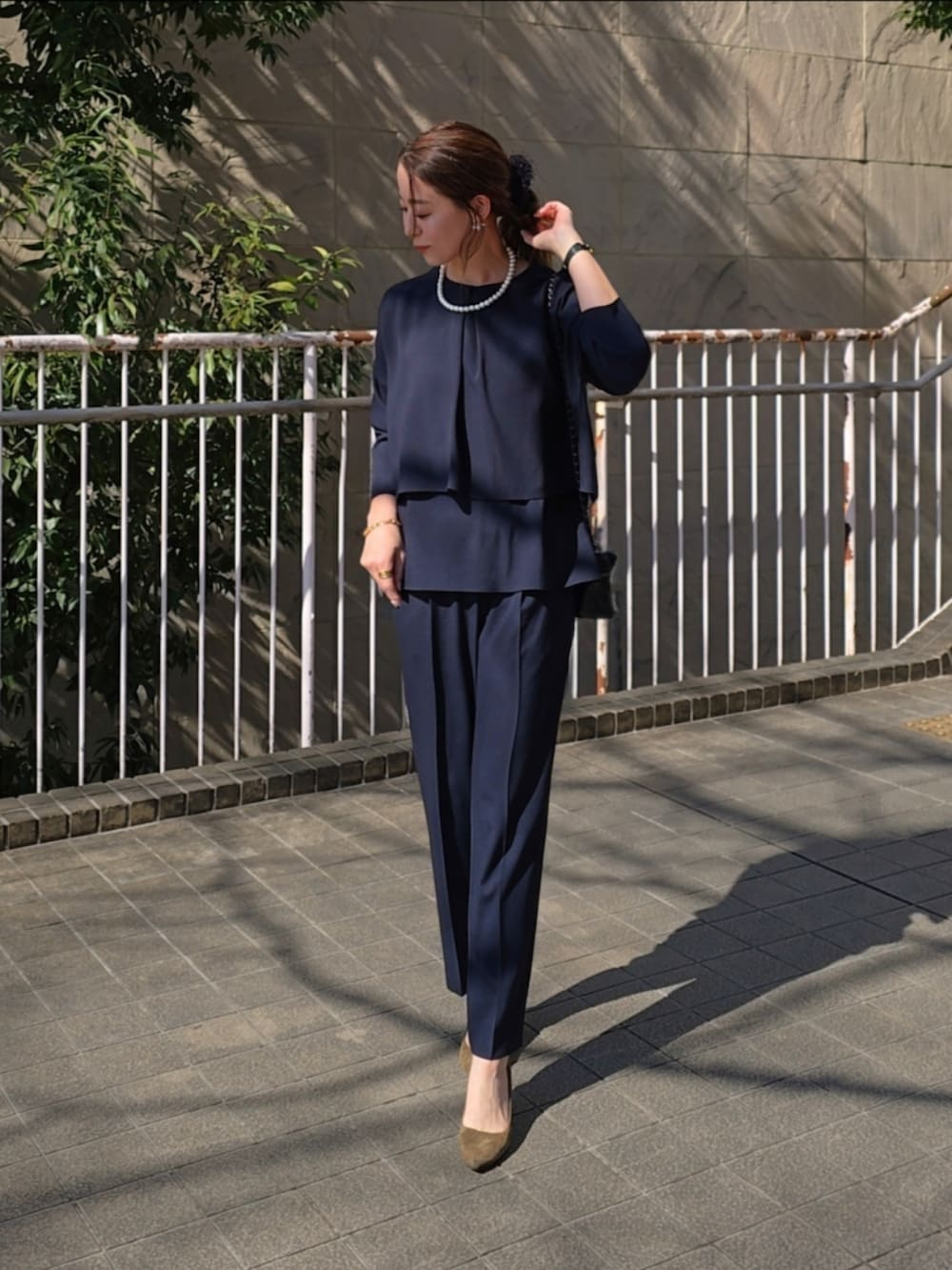 ブラック系のスーツセットを着用したレディースの春コーディネートの2枚目の写真