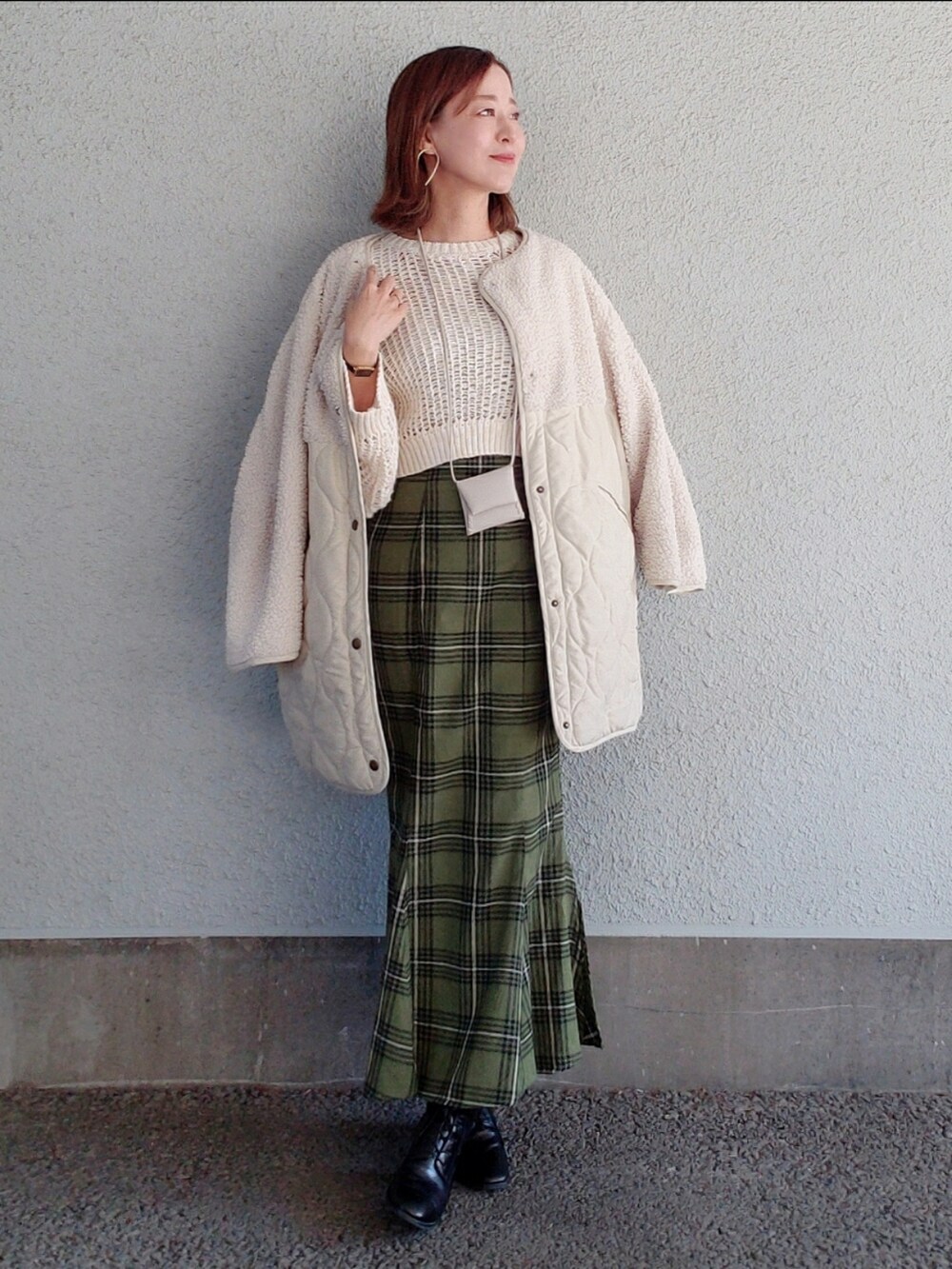 ホワイト系のニット/セーター、グリーン系のスカート、ブラック系のブーツを着用したレディースの冬コーディネートの3枚目の写真