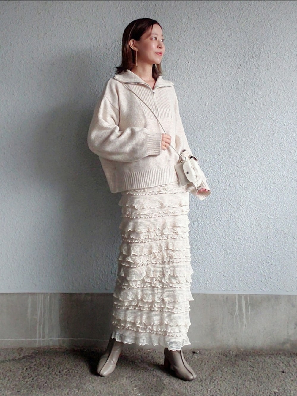 ホワイト系のスカート、グレー系のブーツ、ホワイト系のトレンチコートを着用したレディースの春コーディネートの2枚目の写真