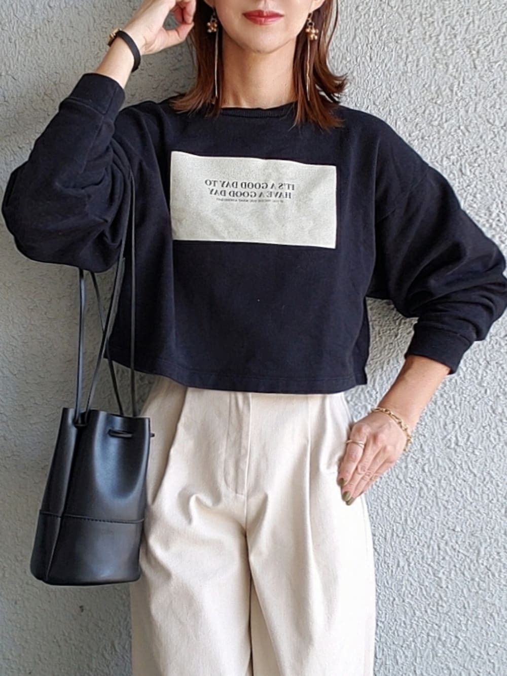 ブラック系のスウェット、ブラック系のハンドバッグ、ベージュ系のその他パンツを着用したレディースの秋コーディネートの3枚目の写真