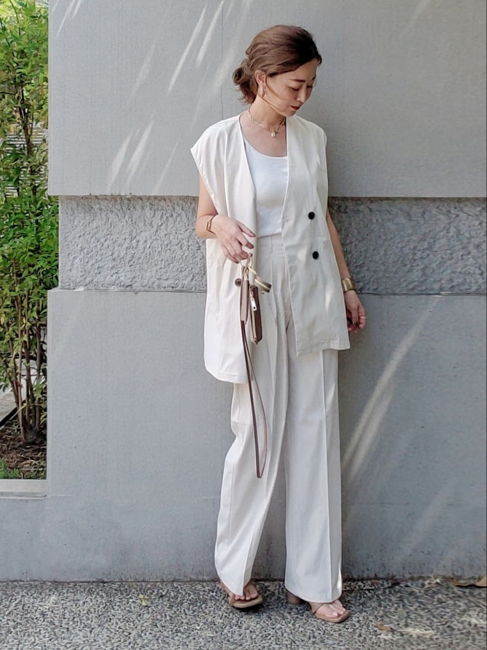 ホワイト系のフォーマルスーツ/小物、ブラウン系のサンダル、ブラック系の腕時計を着用したレディースの夏コーディネートの2枚目の写真