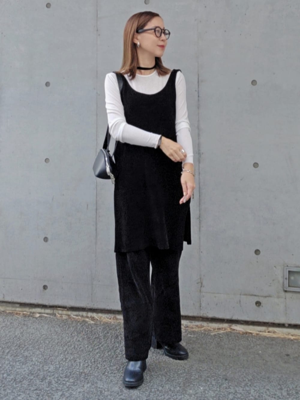 ブラック系のワンピース、ブラック系のパンツ、ブラック系のブーツを着用したレディースの秋コーディネートの3枚目の写真