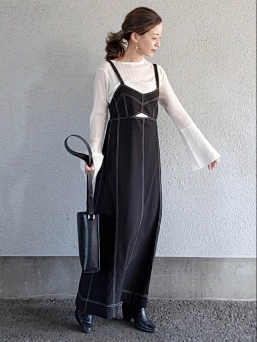 ブラック系のワンピース/ドレス、ブラック系のバッグ、ホワイト系のニット/セーターを着用したレディースの春コーディネートの2枚目の写真