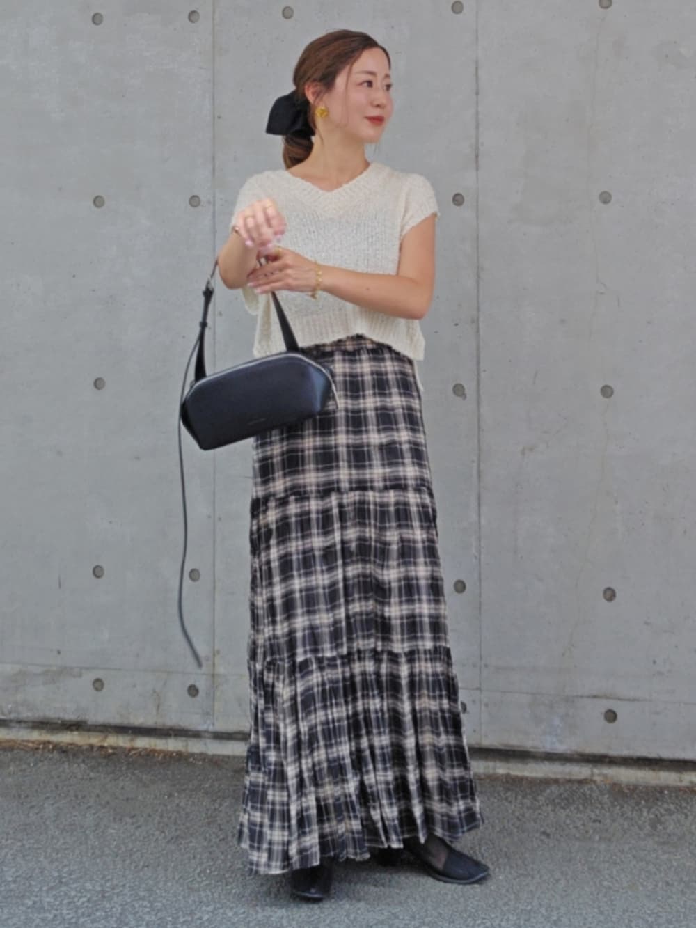 ホワイト系のトップス、ブラック系のスカート、ブラック系のショルダーバッグを着用したレディースの夏コーディネートの2枚目の写真