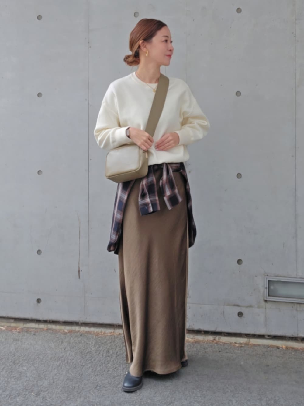 グリーン系のスカート、ベージュ系のバッグを着用したレディースの冬コーディネートの3枚目の写真