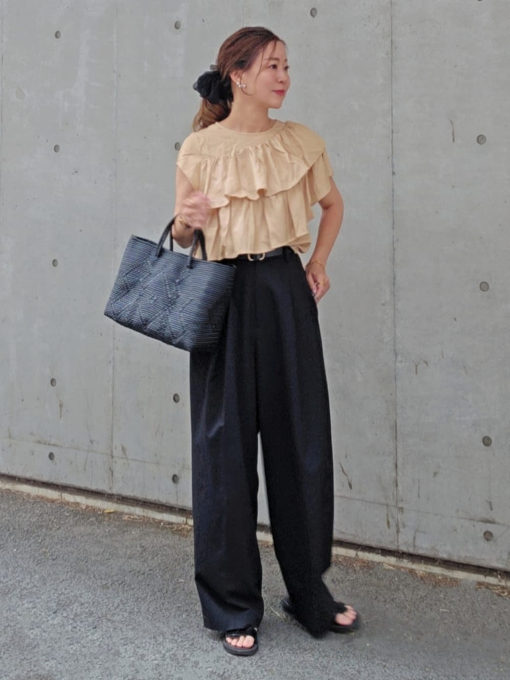 ベージュ系のシャツ/ブラウス、ブラック系のスラックス、ブラック系のサンダルを着用したレディースの夏コーディネートの3枚目の写真