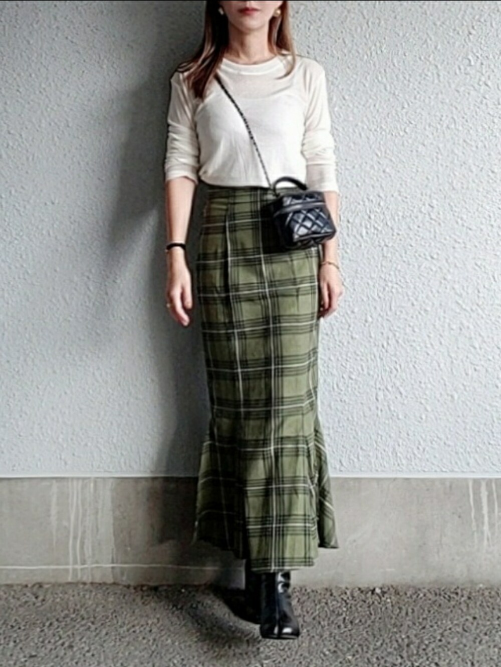 グリーン系のスカート、ブラック系のブーツ、ホワイト系のTシャツ/カットソーを着用したレディースの秋コーディネートの4枚目の写真