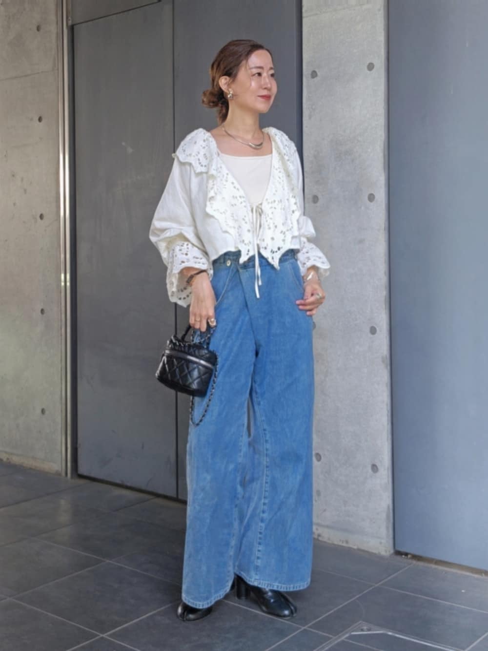 ホワイト系のシャツ/ブラウス、ブルー系のデニムパンツ、ブラック系のパンプスを着用したレディースの春コーディネートの2枚目の写真