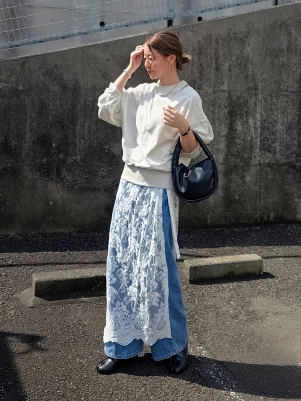 ベージュ系のTシャツ/カットソー、ホワイト系のスカート、ブルー系のデニムパンツを着用したレディースの春コーディネートの3枚目の写真