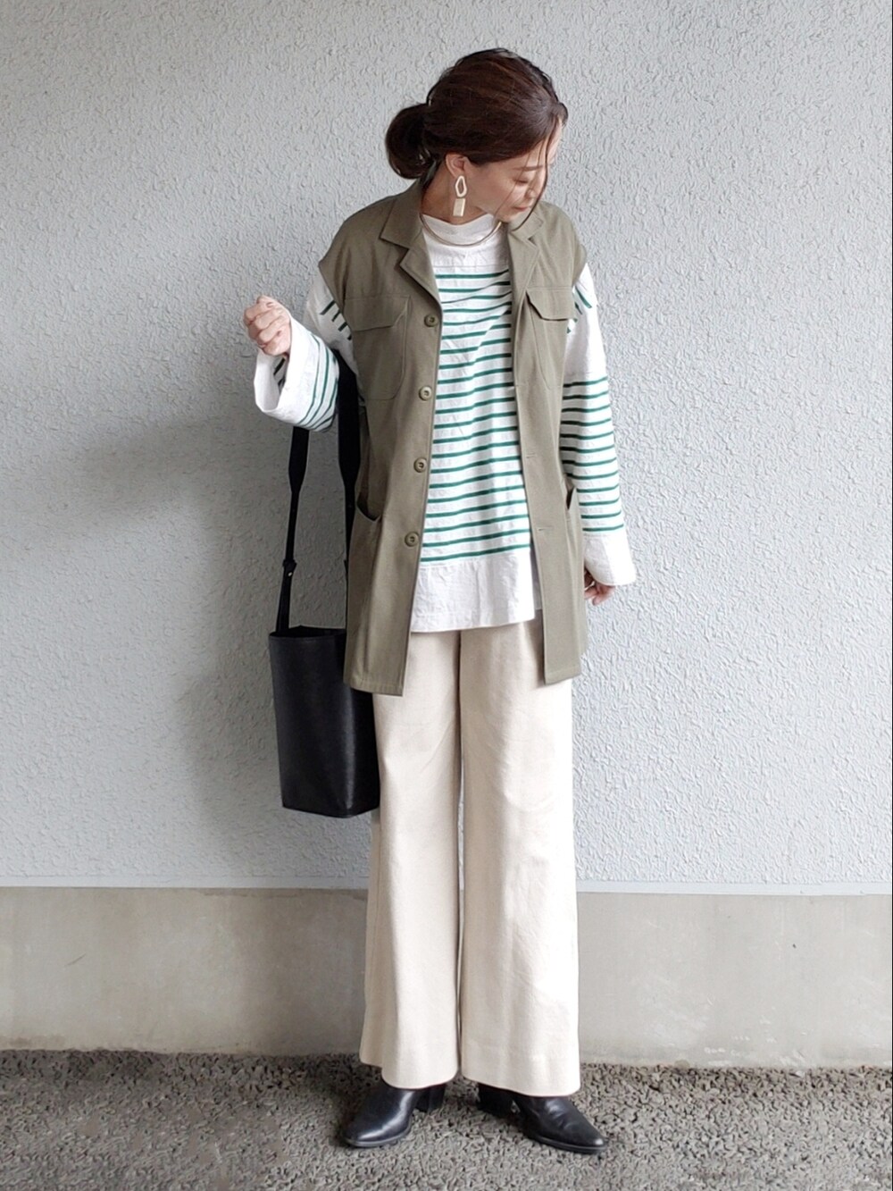 ベージュ系のその他パンツ、グリーン系のベスト、グリーン系のTシャツ/カットソーを着用したレディースの春コーディネートの2枚目の写真