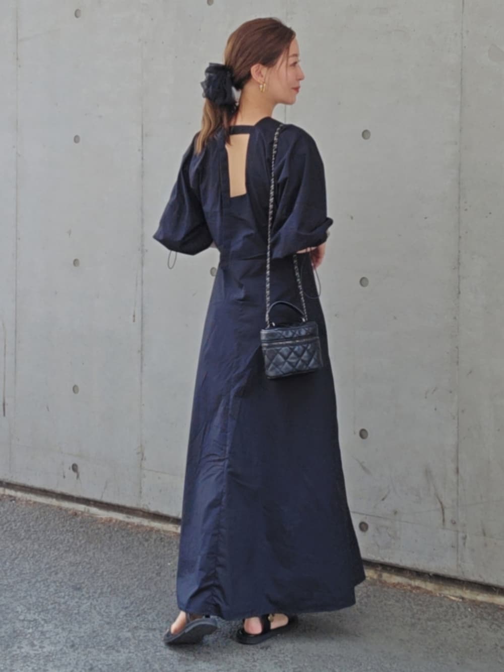 ブラック系のワンピース/ドレス、ブラック系のバッグ、ブラック系のサンダルを着用したレディースの夏コーディネートの2枚目の写真